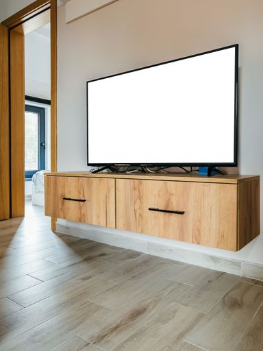 A vertical shot of a TV with a white screen on a wooden counter