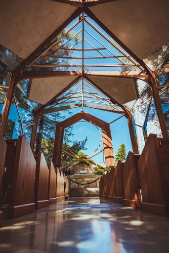 A vertical low angle shot of the Wayfarers Chapel in the daytime with a clear blue sky