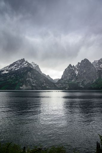A vertical shot of Jenny Lake at the base of the Tetons during a rainstorm