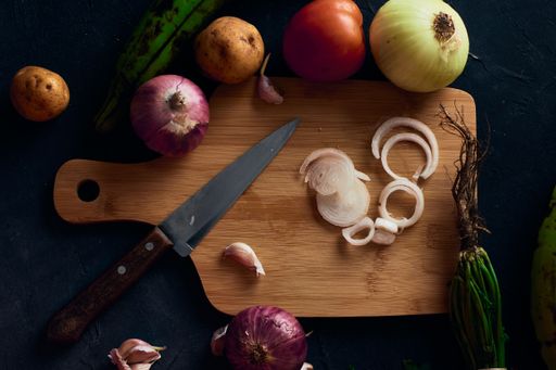 A top view of a sliced onion on a wooden cutting board