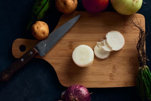 A top view of a sliced onion on a wooden cutting board