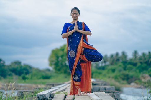 A selective focus shot of a Yogini doing Asana in an ancient temple
