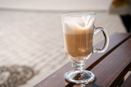 An Irish coffee glass on a wooden table