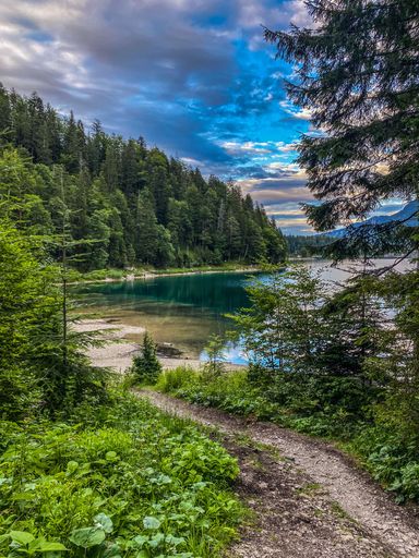 A vertical shot of the Eibsee lake in the Garmisch Partenkirchen town, Germany with trees in the back