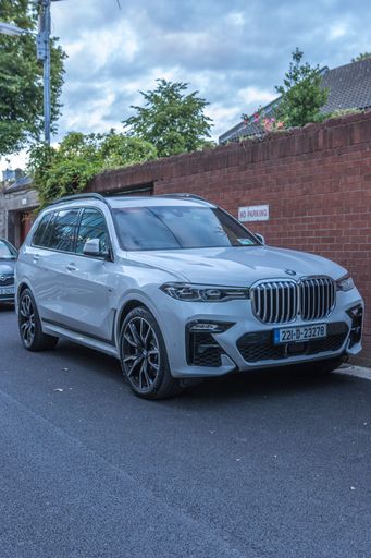 Dublin, Ireland - July 7 2022. A scenic shot of a BMW X7 parking in street of Dublin, in front of building during sunset