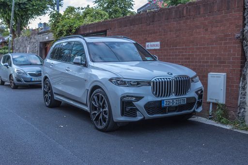 Dublin, Ireland - July 7 2022. A scenic shot of a BMW X7 parking in street of Dublin, in front of building during sunset