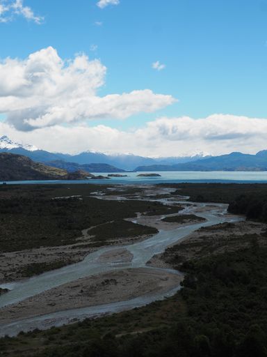 A vertical high angle shot of a beautiful scenery of a lake and mountains on a sunny day