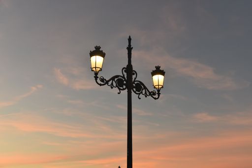 A low angle shot of street lights under the beautiful sunset sky