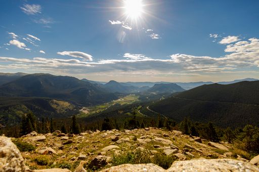A range of mountains with a blue cloudy sky in the background on a sunny day