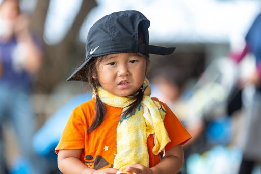 The close-up portrait of an Asian Girl with a black cap on her head and a yellow scarf