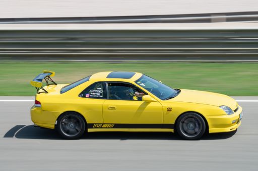 A Japanese yellow Honda Prelude car skidding on a circuit