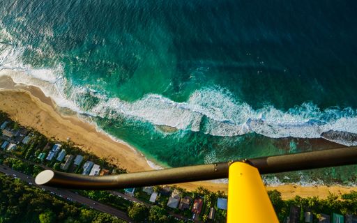 A view from a helicopter of waves covering the coastline