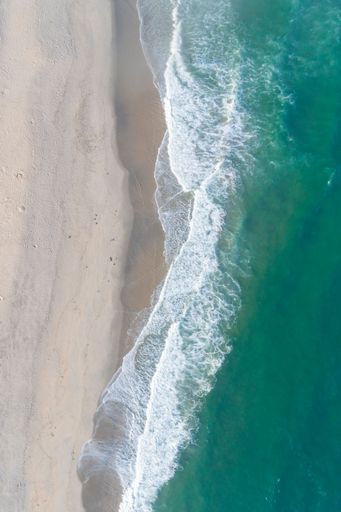 Beautiful white empty beach and sea waves seen from above. Aerial view