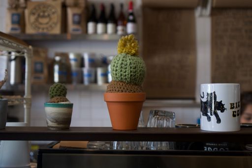 A closeup shot of two clay pots with knitted cacti in a kitchen