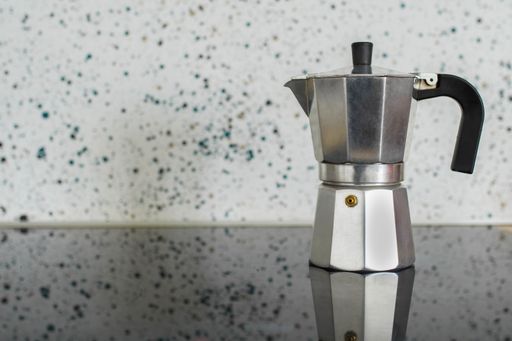 Picture of Classic Italian Coffee Maker Silver Color On Stove Top with Embossed Wall Background. Concept of Properties of Coffee or Household Utensil