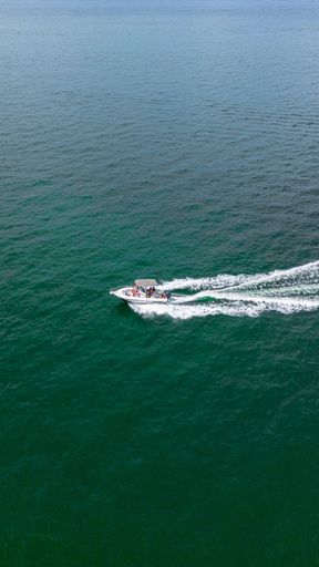 A vertical shot of a yacht sailing in the ocean
