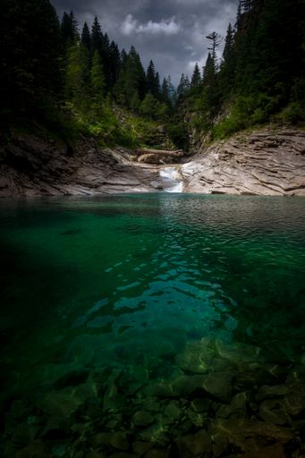 The green lake of Campliccioli on the Italian alps during a moody day in summer