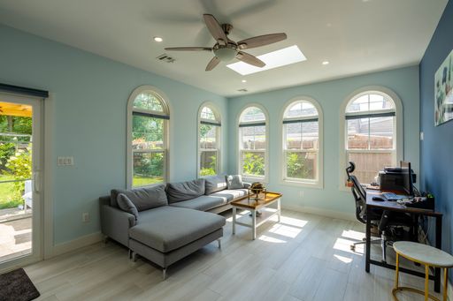 An interior of a modern renovated and furnished living-room with several windows