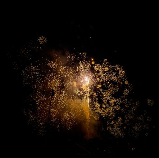 A beautiful shot of golden fireworks spread all over the black background