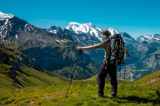 A hiker standing on the Bernese Oberland hiking ridge with mountain landscape in Switzerland