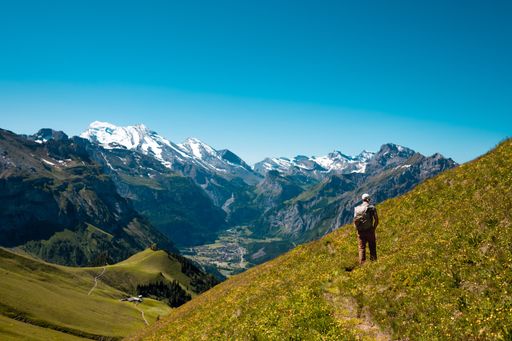 A hiker standing on the Bernese Oberland hiking ridge with mountain landscape in Switzerland