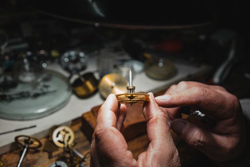 A high angle shot of a male working on repairing a watch