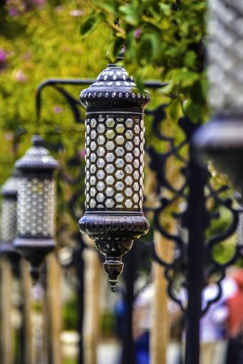 A vertical shot of a street lantern with beautiful patterns on a blurred green background