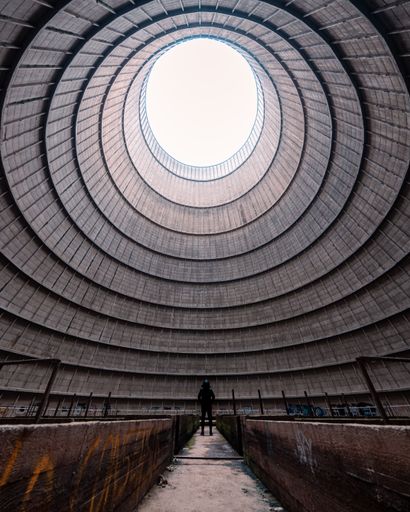 A back view of a man standing inside Power Plant IM-site abandonne in Charleroi, Belgium