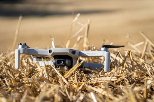 A closeup shot of a Drone Mavic mini from Dji in a dry field