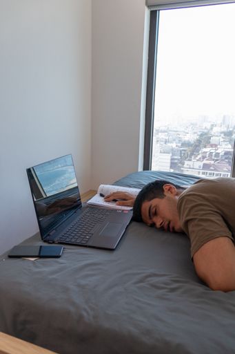 A vertical shot of a young Caucasian male procrastinating - study at home concept