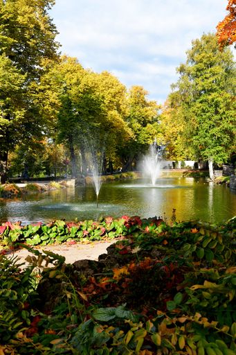 A beautiful autumn park with colorful foliage and splashing water fountains