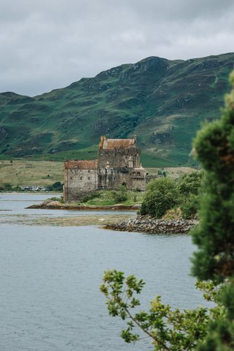 A vertical distant view of the Eilean Donan Castle at the coast of a river in Skye island, Scotland, UK