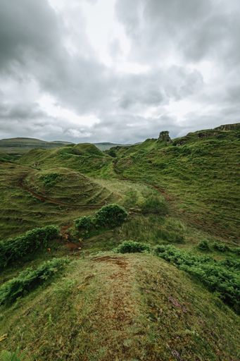 A vertical shot of hills and trees on Skye island on a gloomy day
