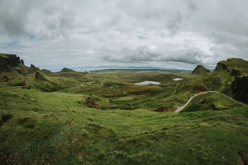 A vertical of hills and lake on Isle of Skie island in Scotland captured under a grey cloudy sky
