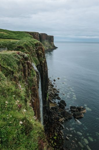 A vertical of a a waterfall on a cliff  on the Isle of Skie island in Scotland