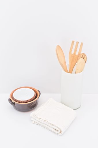 kitchenware and earthenware on a white desk against white wall