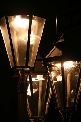 An image of three lanterns with lights in the dark.