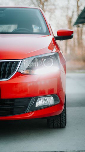 A vertical front view of a red car headlight
