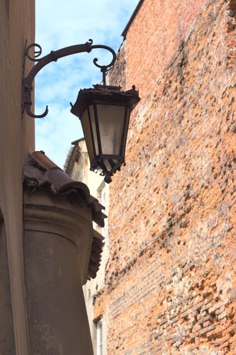 A vertical shot of a vintage street lamp hanging on a wall