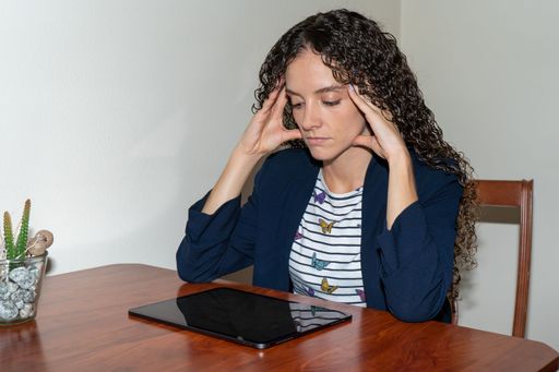 stressed young woman working from home with a tablet