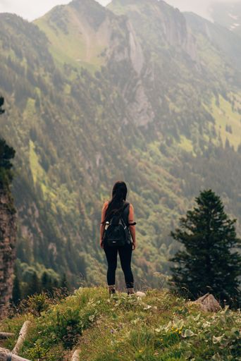 A vertical shot of a woman hiking in the Appenzell Alps in Switzerland