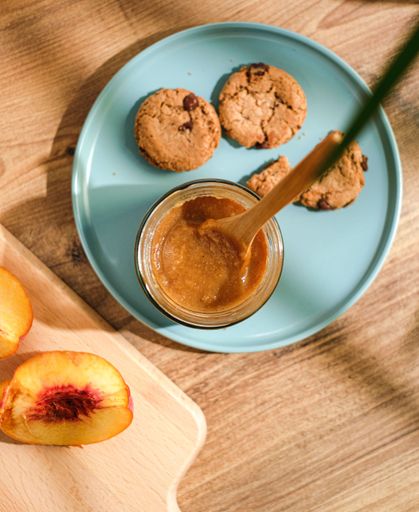 The top view of cookies and peanut butter in the blue plate on the wooden surface
