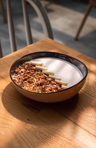 The vertical view of a bowl of cereal on the wooden table