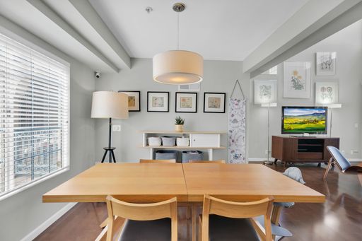 A luxury design of gray living room with corner lamps, table with chairs, TV and vertical blinds