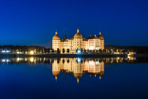 A breathtaking shot of the famous German Moritzburg Castle reflecting in the river during nighttime
