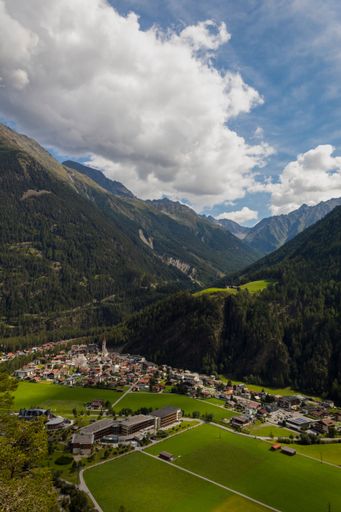 A vertical shot of small houses near the beautiful mountains