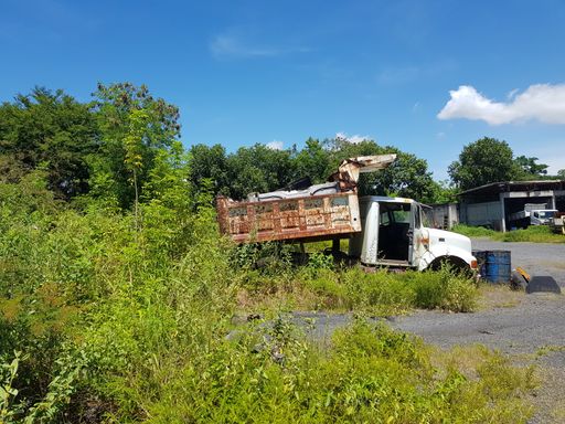 An old abandoned truck rusting in the middle of the grass