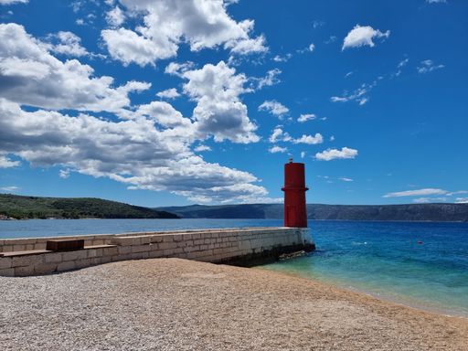 A scenic view of a lighthouse on the beach on island Cres in Croatia in sunny weather