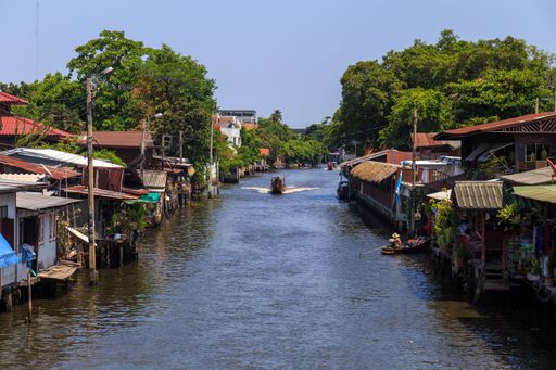 The floating houses on both sides of the canal under blue sky