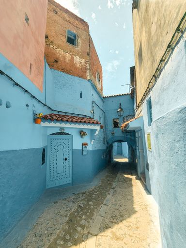 A narrow alley between beautiful blue-washed buildings in Chefchaouen, Morocco